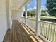 Spacious covered porch with wood flooring and white railings, offering scenic neighborhood views at 4016 Berman Edge Rd, Holly Springs, NC 27540