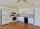 Well-lit kitchen area featuring stainless steel appliances, white cabinetry, and hardwood floors at 4016 Berman Edge Rd, Holly Springs, NC 27540
