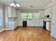 Spacious kitchen with white cabinets, hardwood floors, and a large window for natural light at 4016 Berman Edge Rd, Holly Springs, NC 27540