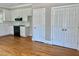 An open kitchen with white cabinets, subway tile, and black appliances is adjacent to wood floors and a double door closet at 4016 Berman Edge Rd, Holly Springs, NC 27540