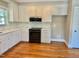 Bright kitchen with white cabinets, granite countertops, stainless steel appliances, and hardwood floors at 4016 Berman Edge Rd, Holly Springs, NC 27540