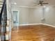 Spacious living room featuring hardwood floors, staircase with black wrought iron spindles and neutral paint at 4016 Berman Edge Rd, Holly Springs, NC 27540