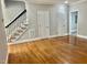 Spacious living room featuring hardwood floors, staircase with black wrought iron spindles and neutral paint at 4016 Berman Edge Rd, Holly Springs, NC 27540