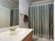Bathroom with a single vanity, tub with shower, and warm color scheme at 404 Settlecroft Ln, Holly Springs, NC 27540