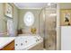 Luxurious bathroom with a soaking tub and separate shower with glass doors at 404 Settlecroft Ln, Holly Springs, NC 27540