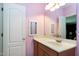 A full bathroom with pink walls has a white sink with a mirror and a white door at 404 Settlecroft Ln, Holly Springs, NC 27540