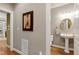 Elegant half bath with pedestal sink, round mirror, and classic design at 404 Settlecroft Ln, Holly Springs, NC 27540