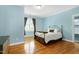 Bright bedroom featuring hardwood floors, a window, and neutral decor at 404 Settlecroft Ln, Holly Springs, NC 27540