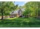 Beautiful brick home with lush landscaping, manicured lawn, and charming blue shutters at 404 Settlecroft Ln, Holly Springs, NC 27540