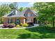 Charming brick home with manicured lawn, blue shutters, and lush landscaping at 404 Settlecroft Ln, Holly Springs, NC 27540