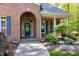 Brick archway over the front entrance with mature landscaping and inviting walkway at 404 Settlecroft Ln, Holly Springs, NC 27540