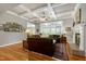 Cozy living room featuring coffered ceilings, hardwood floors, fireplace, and large windows at 404 Settlecroft Ln, Holly Springs, NC 27540