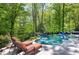 Inviting in-ground pool area with lounge chairs, surrounded by lush greenery and landscaping at 404 Settlecroft Ln, Holly Springs, NC 27540