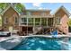 Beautiful brick home with a gorgeous in-ground pool, patio, and outdoor seating areas at 404 Settlecroft Ln, Holly Springs, NC 27540