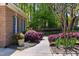 Stone walkway next to brick exterior with blue shutters and mature landscaping at 404 Settlecroft Ln, Holly Springs, NC 27540