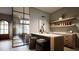 Elegant bar area with marble countertop, seating, and access to a stunning outdoor view through glass doors at 404 Shinleaf Pond Trl, Raleigh, NC 27614
