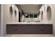 Bathroom featuring a double vanity with wood cabinets, stone countertop, and modern lighting at 404 Shinleaf Pond Trl, Raleigh, NC 27614