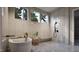 Bright bathroom featuring a soaking tub, three windows, neutral tile, and stylish fixtures at 404 Shinleaf Pond Trl, Raleigh, NC 27614