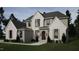 Beautifully designed two-story home boasting stone accents, a covered entryway, and well-manicured landscaping at 404 Shinleaf Pond Trl, Raleigh, NC 27614