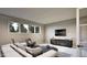 Contemporary living room with stylish sofa, chair, TV, and windows overlooking nature at 404 Shinleaf Pond Trl, Raleigh, NC 27614