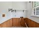Bright laundry room with open shelving and wood paneling at 409 Ivey Rd, Graham, NC 27253