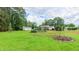 Expansive backyard featuring a lush green lawn, an outbuilding, and a relaxing patio space at 41 Maple Cir, Pittsboro, NC 27312