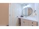 Bathroom with a white vanity, round mirror, and a white door at 41 Maple Cir, Pittsboro, NC 27312