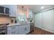 Well-lit kitchen with stainless steel appliances, white cabinets, and a modern sliding barn door at 41 Maple Cir, Pittsboro, NC 27312