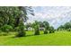 Serene backyard view showcasing a lush green lawn, well-maintained trees, and charming home in the distance at 41 Maple Cir, Pittsboro, NC 27312