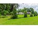 Beautiful backyard landscaping, showcasing a lush green lawn, well-maintained trees, and charming home in the distance at 41 Maple Cir, Pittsboro, NC 27312