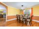 Bright dining room with hardwood floors, a contemporary chandelier, and a pass-through to the kitchen at 412 Collington Dr, Mebane, NC 27302