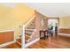 Inviting foyer showcasing wood floors, a staircase with decorative iron railing, and a glimpse into adjacent rooms at 412 Collington Dr, Mebane, NC 27302