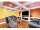 Comfortable living room featuring a fireplace, mounted tv and unique pink ceiling with hardwood floors at 412 Collington Dr, Mebane, NC 27302