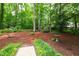 Backyard showcasing the beautiful wooded lot and lush landscaping on the property at 4213 Oak Park Rd, Raleigh, NC 27612