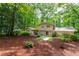 Exterior home elevation featuring a wooded backyard, covered patio and lush landscaping at 4213 Oak Park Rd, Raleigh, NC 27612