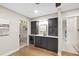 Wet bar area featuring dark cabinets, white countertops, wine fridge and hardwood floors at 4213 Oak Park Rd, Raleigh, NC 27612