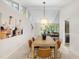 Bright dining room featuring a long wooden table, modern light fixture, and contemporary artwork on the wall at 4213 Oak Park Rd, Raleigh, NC 27612