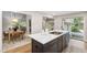 Kitchen featuring an island with white countertop and dark cabinets, open to the dining and living area at 4213 Oak Park Rd, Raleigh, NC 27612