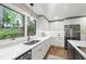 Bright kitchen with white cabinets, marble countertops, stainless steel appliances, and a large window at 4213 Oak Park Rd, Raleigh, NC 27612