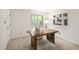 Bright home office with a rustic wooden desk, neutral decor, and a window overlooking a green space at 4213 Oak Park Rd, Raleigh, NC 27612