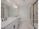 Bathroom with double sinks, a large mirror, white tile, and glass enclosed shower at 452 Golden Dragonfly St, Wake Forest, NC 27587