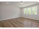 This bedroom has neutral paint color, wood flooring, and a large window with natural light at 452 Golden Dragonfly St, Wake Forest, NC 27587