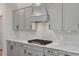 Close up of kitchen features a gas cooktop, white countertops, gray cabinetry, and stylish backsplash at 452 Golden Dragonfly St, Wake Forest, NC 27587