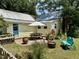 Backyard featuring a brick patio, picnic table, fire pit, bench, and garden beds at 501 N Greensboro St, Carrboro, NC 27510