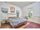 Sun-filled bedroom with wood floors, three large windows, and vintage-style furniture at 501 N Greensboro St, Carrboro, NC 27510