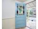 Entryway view of a stained glass, light blue front door leading to the front porch and hardwood flooring at 501 N Greensboro St, Carrboro, NC 27510