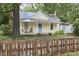 Charming yellow home with a cozy front porch featuring a swing and rocking chair and a brown wooden fence at 501 N Greensboro St, Carrboro, NC 27510