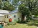 Exterior featuring a large tree, garden beds, and a water collection barrel at 501 N Greensboro St, Carrboro, NC 27510