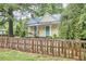 Charming yellow home with a cozy front porch featuring a swing and rocking chair and a brown wooden fence at 501 N Greensboro St, Carrboro, NC 27510