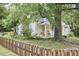 Charming exterior featuring a porch with swing and rocking chair beneath a large tree at 501 N Greensboro St, Carrboro, NC 27510